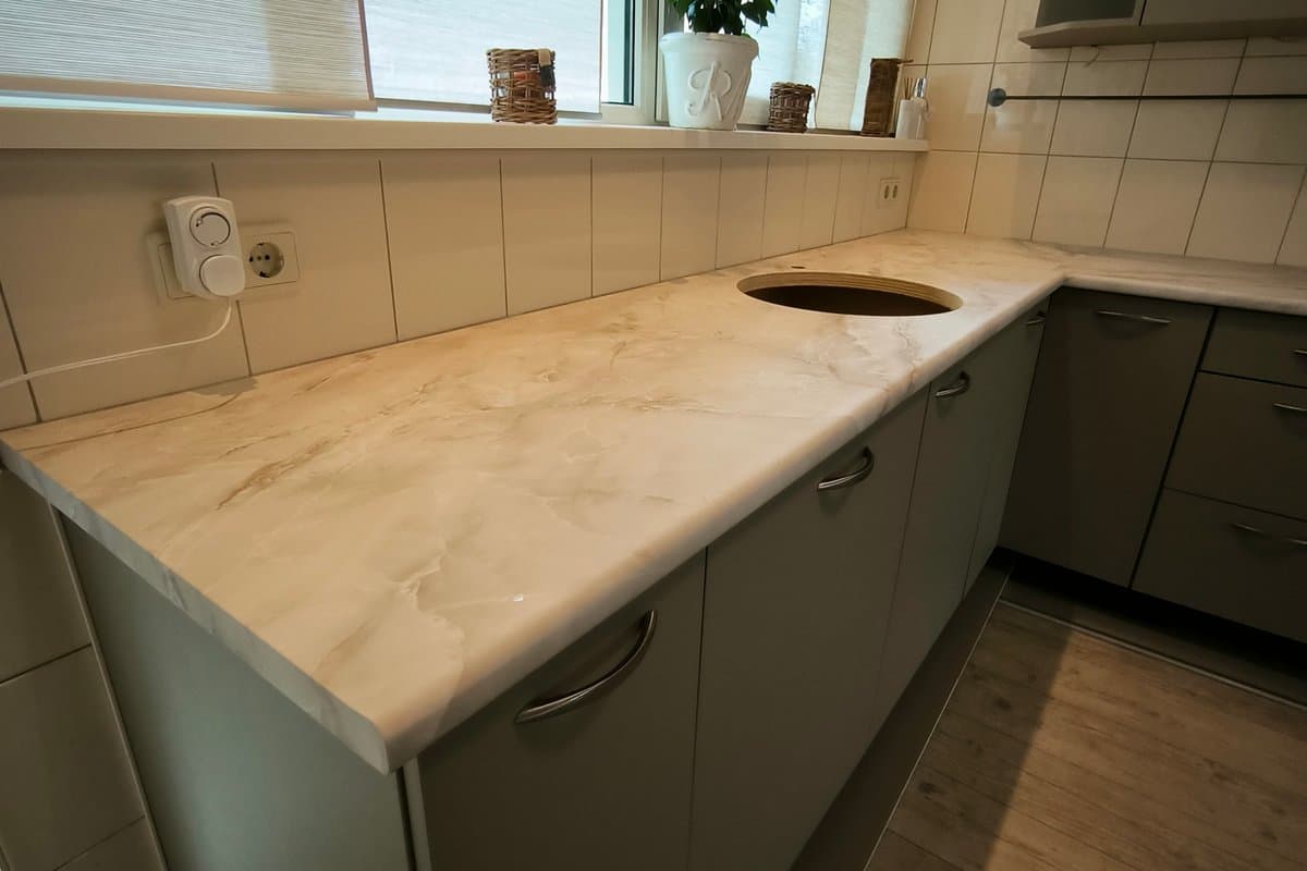 Gewrapt werkblad in marmerlook met groene fronten