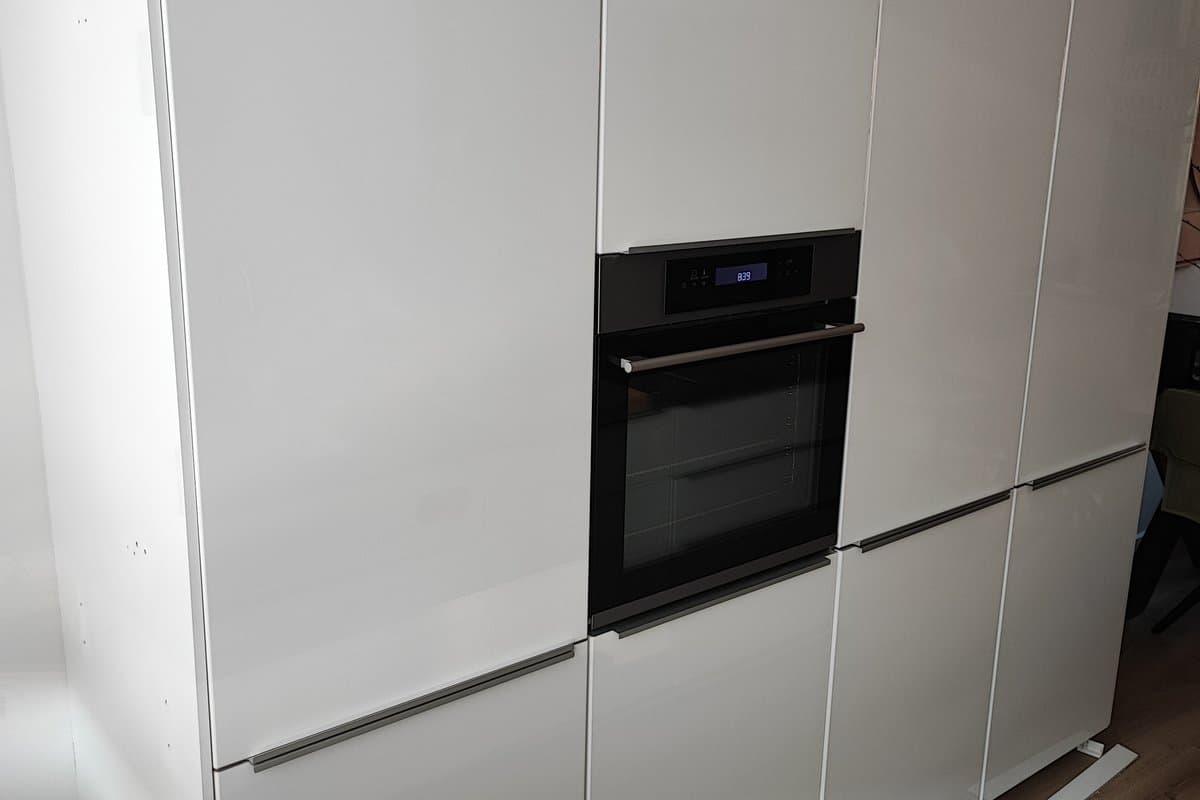 Close-up van gewrapte hoogglans witte keukenfronten met ingebouwde oven